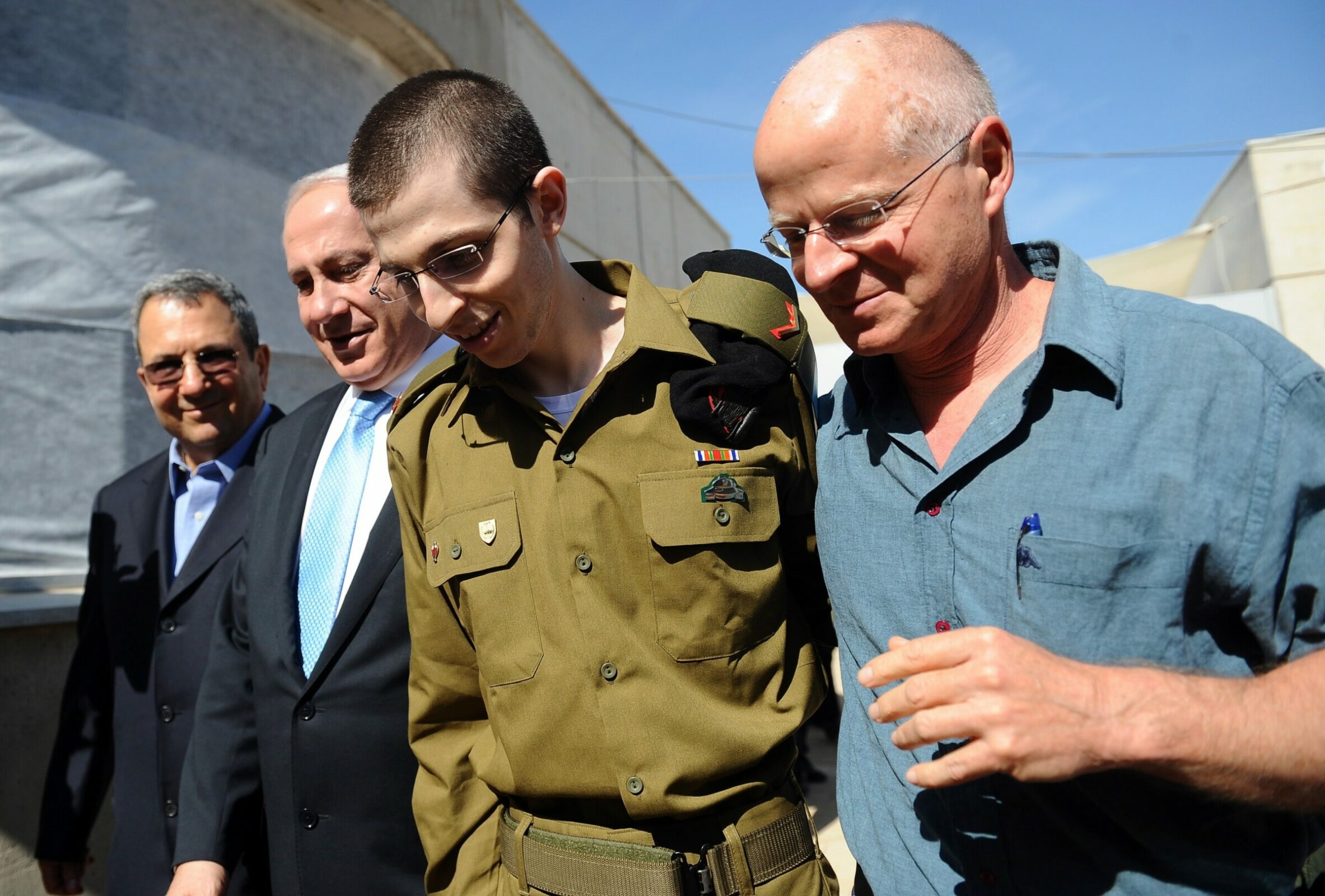 The Israeli Defence Forces (IDF) on 18 October 2011 shows released Israeli soldier Gilad Shalit (center) being accompanied by his father Noam (right), Israeli Prime Minister Benjamin Netanyahu (second from the right), and Defense Minister Ehud Barak (left), as he arrives by helicopter at the Tel Nof air base in central Israel after his release from 1,941 days of captivity in the Gaza Strip, on 18 October 2011. Shalit was released in exchange for 1,027 Palestinians in Israeli jails.