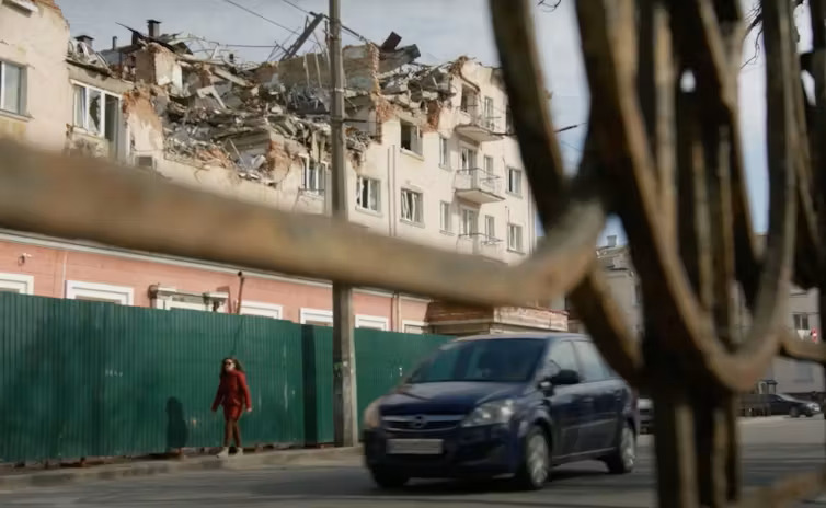 A car passes in front of a destructed hotel in  in Chernihiv, Ukraine in March 2023